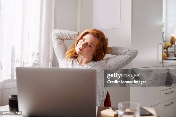 woman stretching while using laptop - neckache stock pictures, royalty-free photos & images