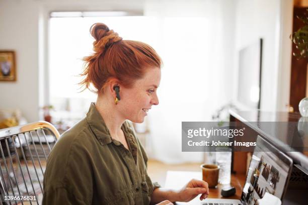 woman using laptop - cheveux roux photos et images de collection