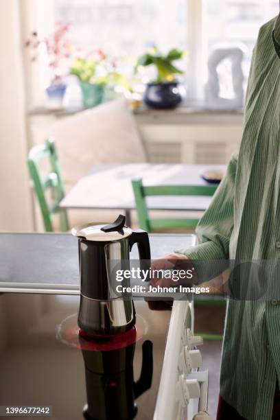woman preparing coffee on electric stove burner - electric stove burner ストックフォトと画像