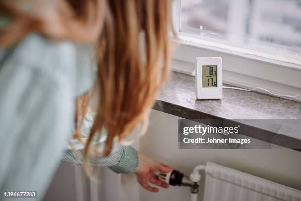 hand adjusting temperature control in radiator - energy efficiency stock pictures, royalty-free photos & images