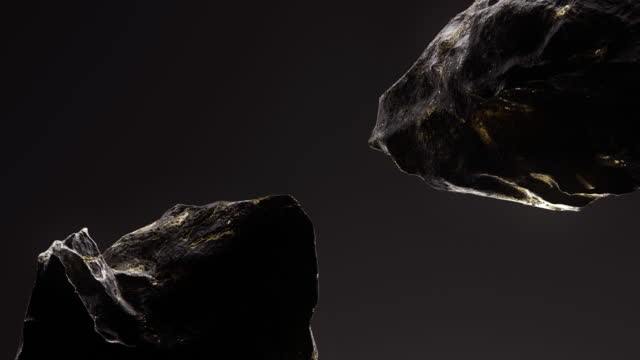 Abstract 3D animation of a black stone with golden veins spinning in weightlessness. Soft light illuminates the texture of the stone.
