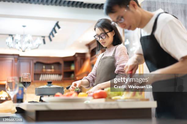 happy couple cooking food together at home - asian couple dinner stock pictures, royalty-free photos & images