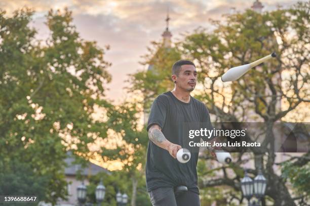 young man juggling outdoors - juggling stock pictures, royalty-free photos & images