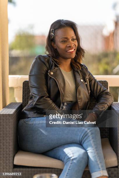 african american woman smiling while relaxing with friends outdoors at home. - familie sofa stock pictures, royalty-free photos & images