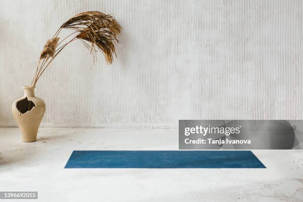 an empty hall with a yoga mat on the floor - yoga studio stock-fotos und bilder