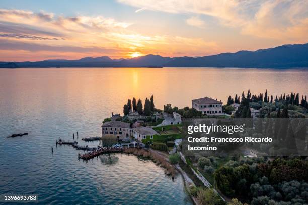 punta san vigilio at sunset, aerial view. east coast of garda lake in springtime. - veneto stockfoto's en -beelden