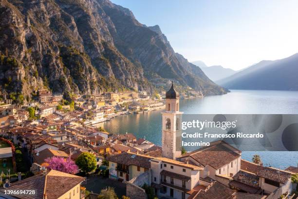 garda lake, lombardy. aerial view of limone sul garda church and town on the shore. italy - lago di garda - fotografias e filmes do acervo