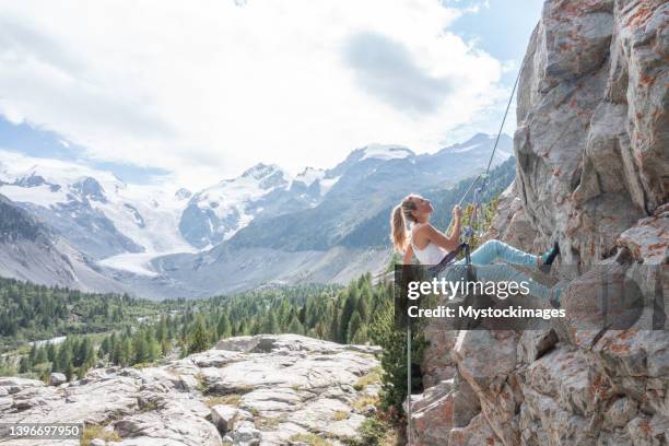 drone view of female mountain climber rappelling on rock face - 爬山繩 個照片及圖片檔