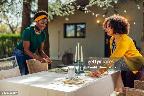 two women preparing table for dinner party in the backyard - setting the table stock pictures, royalty-free photos & images