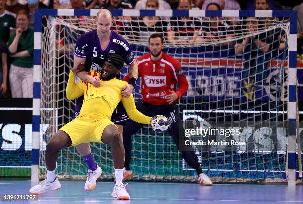 Simon Jensen of SG Flensburg-Handewitt challenges Dika Mem of FC Barcelona during the EHF Champions League Quarter Final between SG...