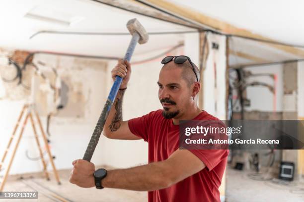 construction worker with demolition hammer in a home renovation - sledgehammer stockfoto's en -beelden