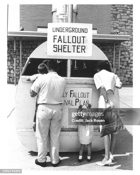 Outside Shop-A-Rama, also known as Levittown Shopping Center , a couple and two children inspect a demonstration fallout shelter, Levittown,...