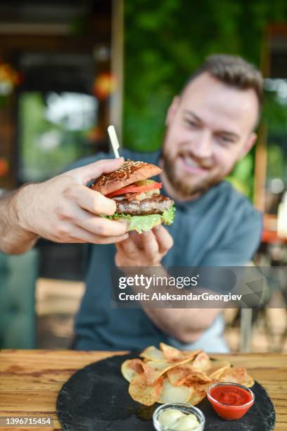 hora de la cena de hamburguesas para un hombre sonriente barbudo - male burger eating fotografías e imágenes de stock