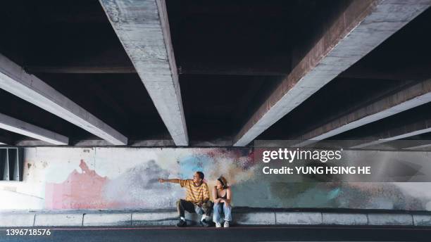 in asien unterhalten sich zwei junge taiwanesische millennials in einer unterführung. - wide stock-fotos und bilder