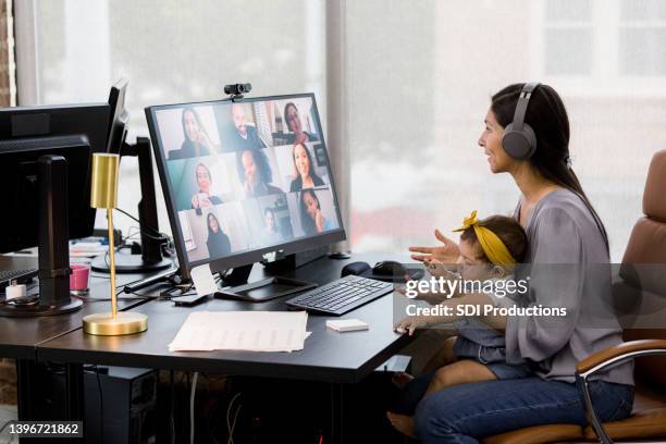 mom uses co-working space to teleconference co-workers - mãe trabalhadora imagens e fotografias de stock
