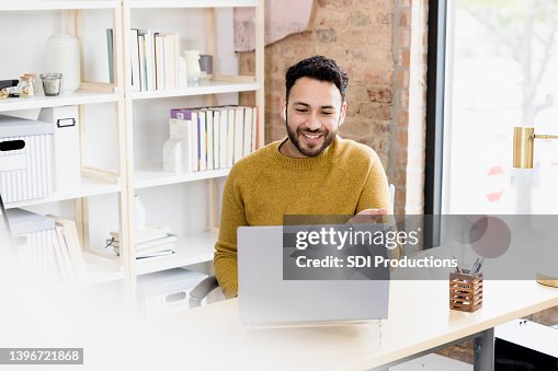 Man uses laptop to video conference with friends Man uses laptop to video conference with friends