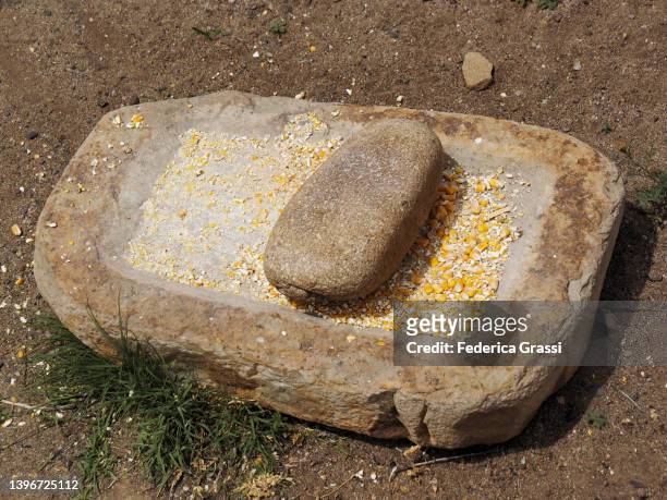 ancient metate, concave stone used for grinding grains at aztec ruins national monument, new mexico. - azteca fotografías e imágenes de stock
