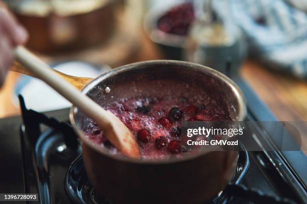 cooking cranberries in domestic kitchen - cranberry sauce 個照片及圖片檔