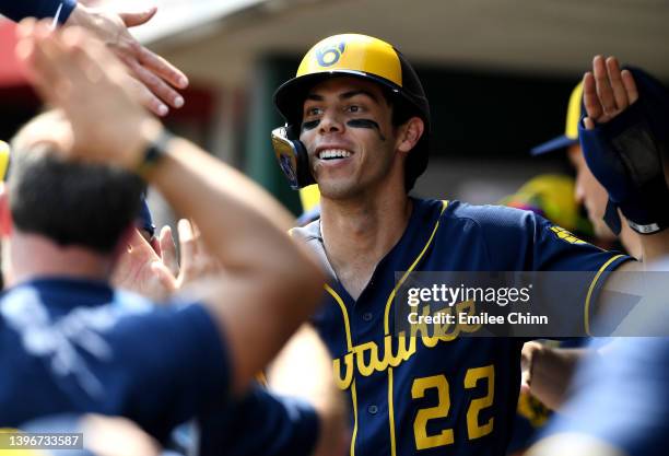 Christian Yelich of the Milwaukee Brewers celebrates in the dugout after hitting a triple for a cycle in the ninth inning during a game against the...
