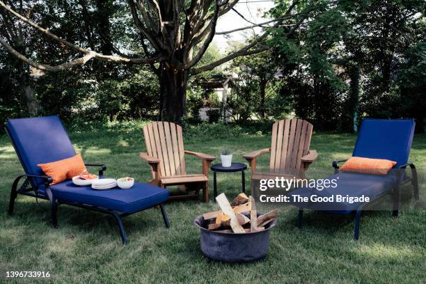 empty chairs and fire pit in back yard - silla de jardín fotografías e imágenes de stock