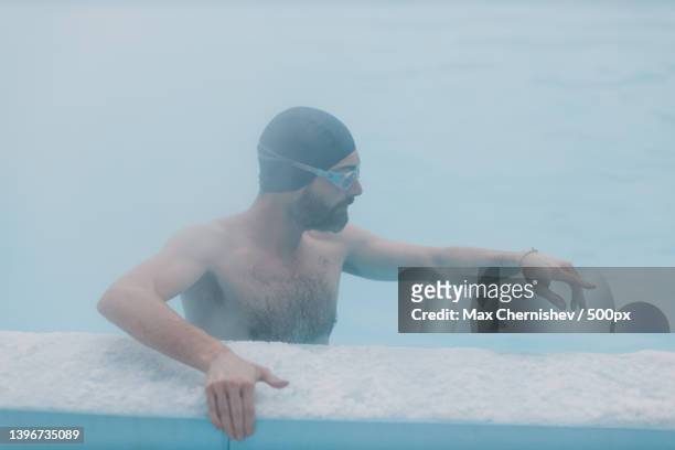 fit swimmer male training swim in open winter swimming pool with fog - winter swimming stock pictures, royalty-free photos & images