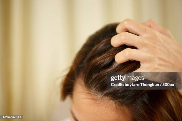 a woman has problems with hair,close-up of woman with hand in hair - caspa - fotografias e filmes do acervo