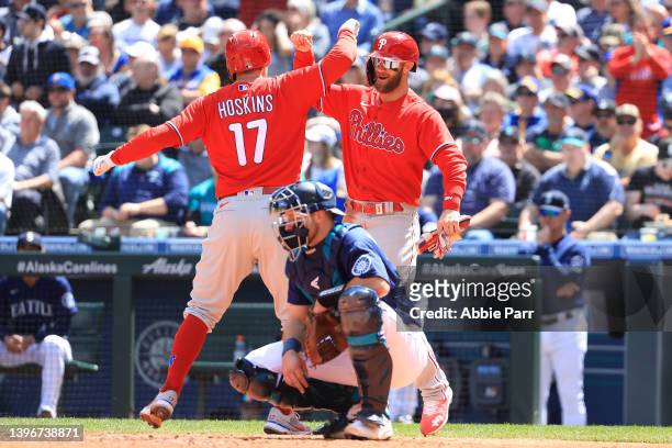 Rhys Hoskins of the Philadelphia Phillies celebrates with Bryce Harper after hitting a grand slam to take a 4-1 lead against the Seattle Mariners...