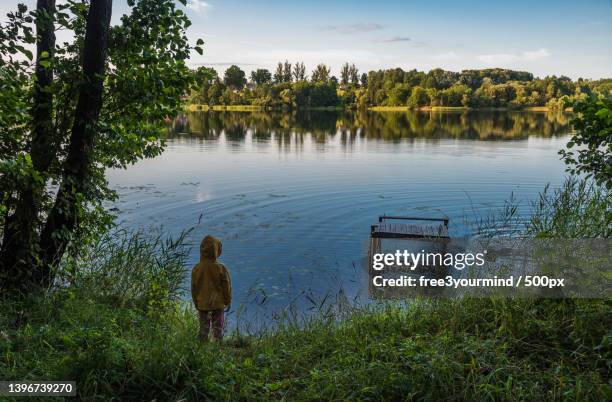 rear view of man standing by lake against sky,braslaw,belarus - braslaw stock pictures, royalty-free photos & images