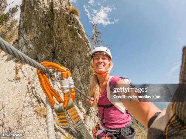 woman takes a selfie during a climb in the alps - women rock climbing stock pictures, royalty-free photos & images