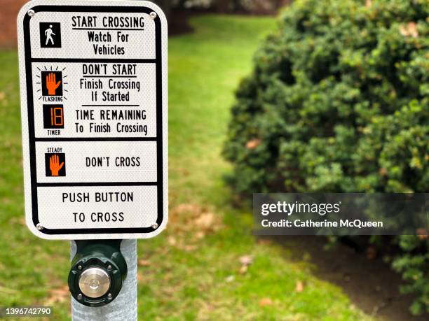 “push button to cross” crosswalk sign on metal pole with other crossing instructions - collision avoidance stock pictures, royalty-free photos & images