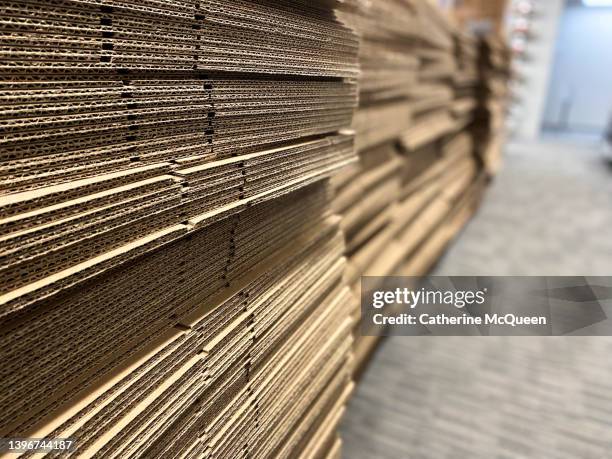 side view with diminishing perspective of stack of cardboard boxes - packaging foto e immagini stock