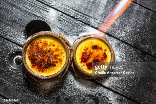 creme brulee auf einem dunklen tisch - creme brulee stock-fotos und bilder