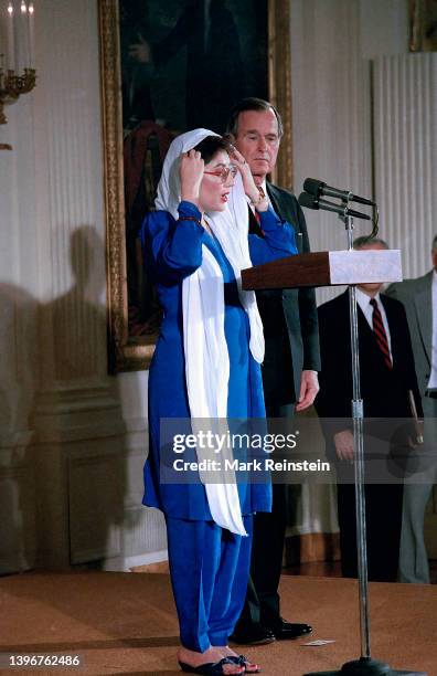 Pakistani Prime Minister Benazir Bhutto and United States President George H.W. Bush stand together to deliver remarks in the East Room of the White...