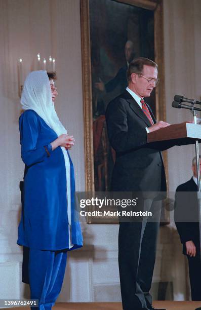 Pakistani Prime Minister Benazir Bhutto and United States President George H.W. Bush stand together to deliver remarks in the East Room of the White...