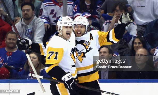 Kris Letang of the Pittsburgh Penguins celebrates his second period goal against the New York Rangers and is joined by Evgeni Malkin in Game Five of...