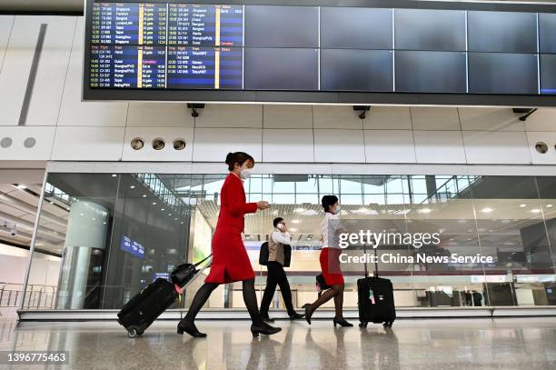 Flight attendants of the Cathay Pacific Airways Ltd. Walk through the arrival hall of the Hong Kong International Airport on April 1, 2022 in Hong...