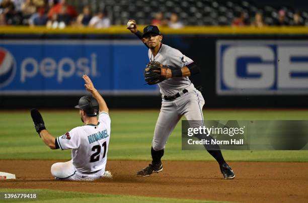 Erik Gonzalez of the Miami Marlins attempts to turn a double play as Cooper Hummel of the Arizona Diamondbacks slides into second base at Chase Field...