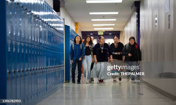 teacher walking among a group of middle and high school kids alongside a corridor - american tribal culture stock pictures, royalty-free photos & images