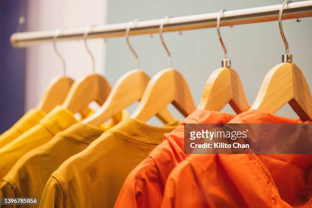 clothing store window display with all orange color clothes - all shirts stock-fotos und bilder