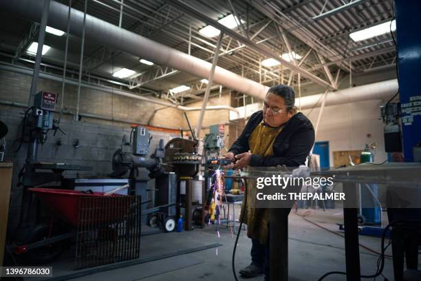 senior metal worker with cutting torch in monument valley, utah - metaalbewerking stockfoto's en -beelden
