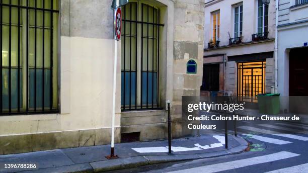 a crossroads of empty streets in paris in the early evening with a lighted building door - the marais stock pictures, royalty-free photos & images