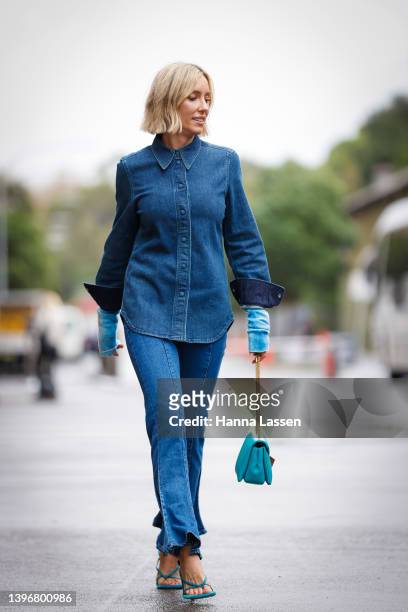 Suzy Eskander wearing denim shirt and flare jeans, blue leather bag and Bottega Veneta blue strap heels at Afterpay Australian Fashion Week 2022 on...