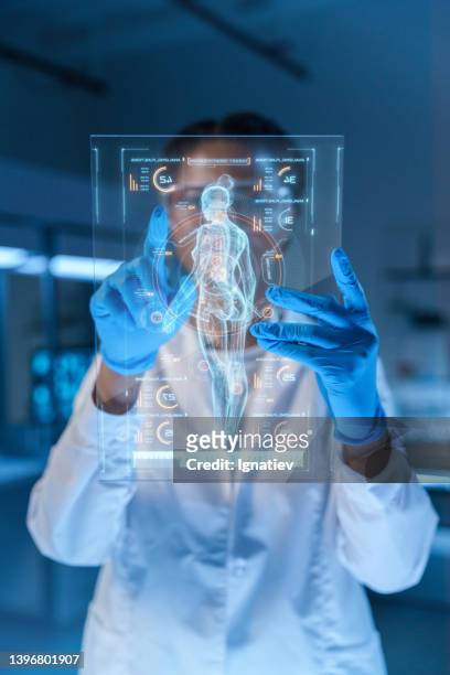 un piccolo hud con un'immagine del corpo umano e uno scienziato o un medico, che lavora con esso - computer mockup foto e immagini stock