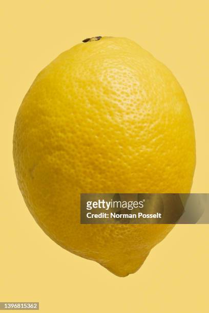 close up dimples on vibrant, whole yellow lemon - lemon stock pictures, royalty-free photos & images