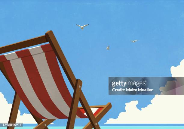 seagulls flying in summer blue sky over striped beach chair - holiday stock illustrations