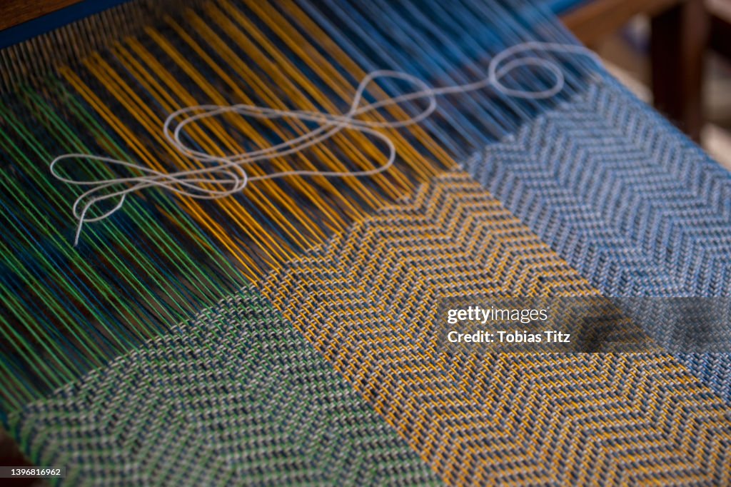 Blue, green and orange thread on loom