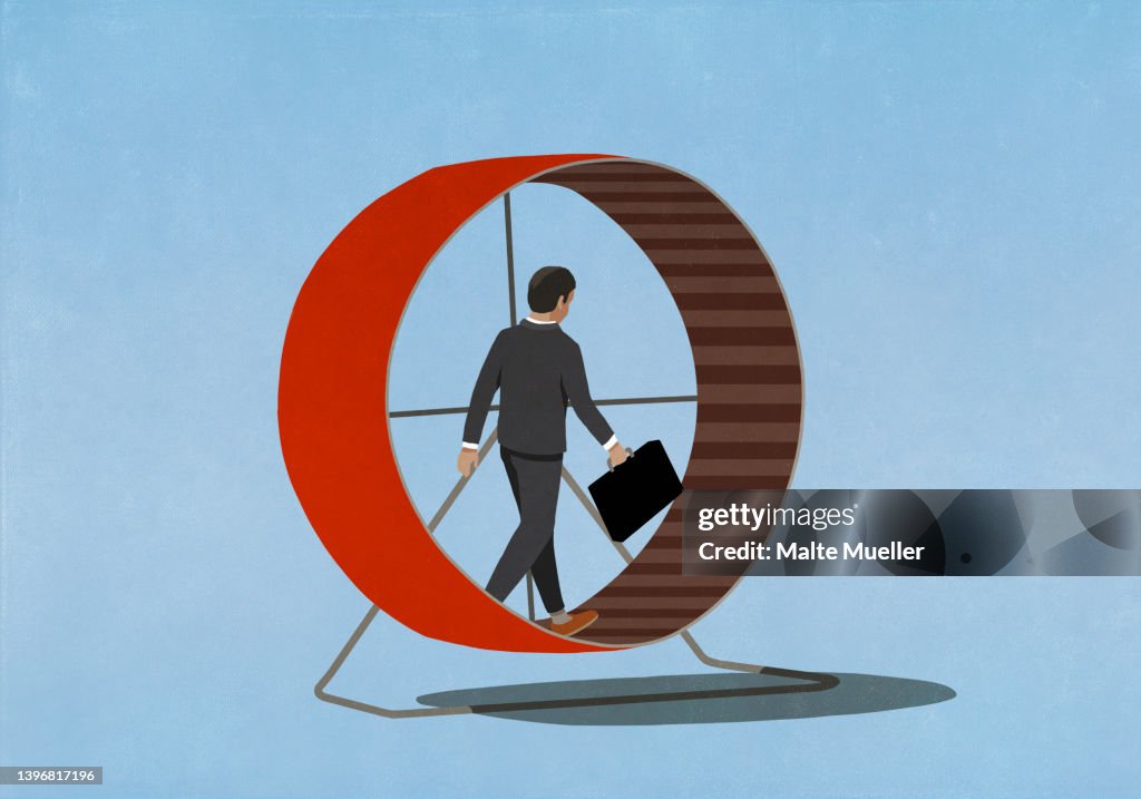 Businessman with briefcase walking in hamster wheel