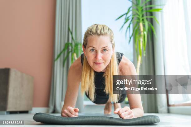 powerful sportive woman stand in plank posture of yoga, joying asana as fitness instructor - plank exercise foto e immagini stock