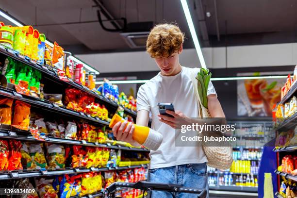 joven escaneando bebida en tienda de comestibles - lector de código de barras fotografías e imágenes de stock