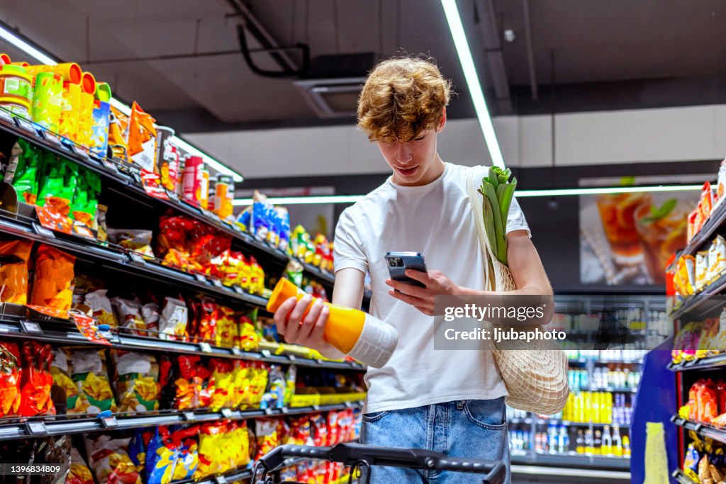 Young man scanning drink in grocery store
